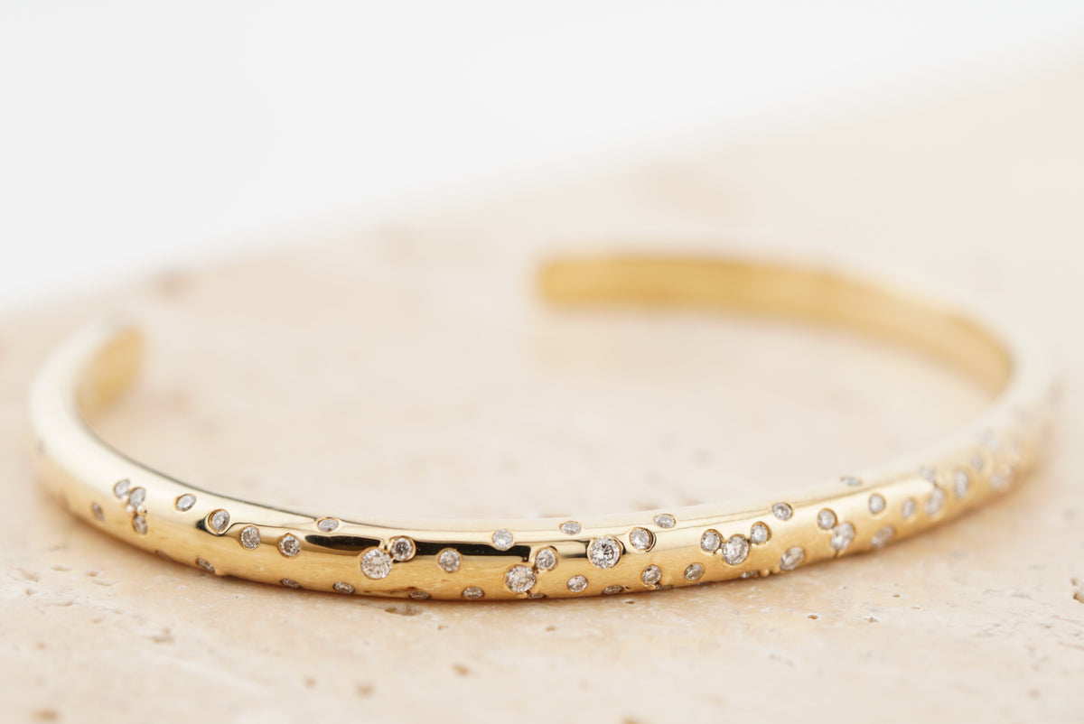 Stella Bracelet in 10K yellow gold with flush-set round lab-grown diamonds, on travertine